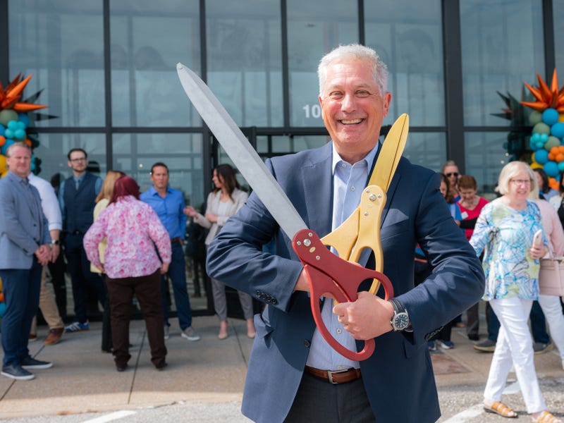Slumberland Furniture CEO Kenny Larson prepares to cut the ribbon on the company's new Sunset Hills store