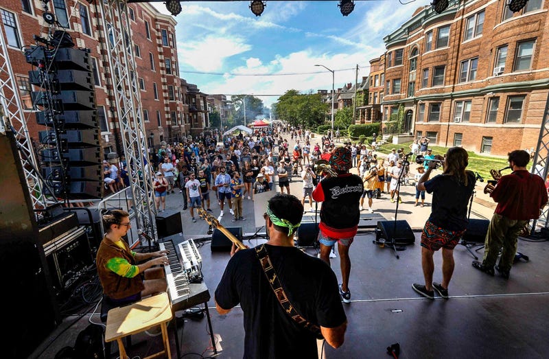 View from Dally in the Alley stage while band plays in front of a crowd standing in the street between two buildings