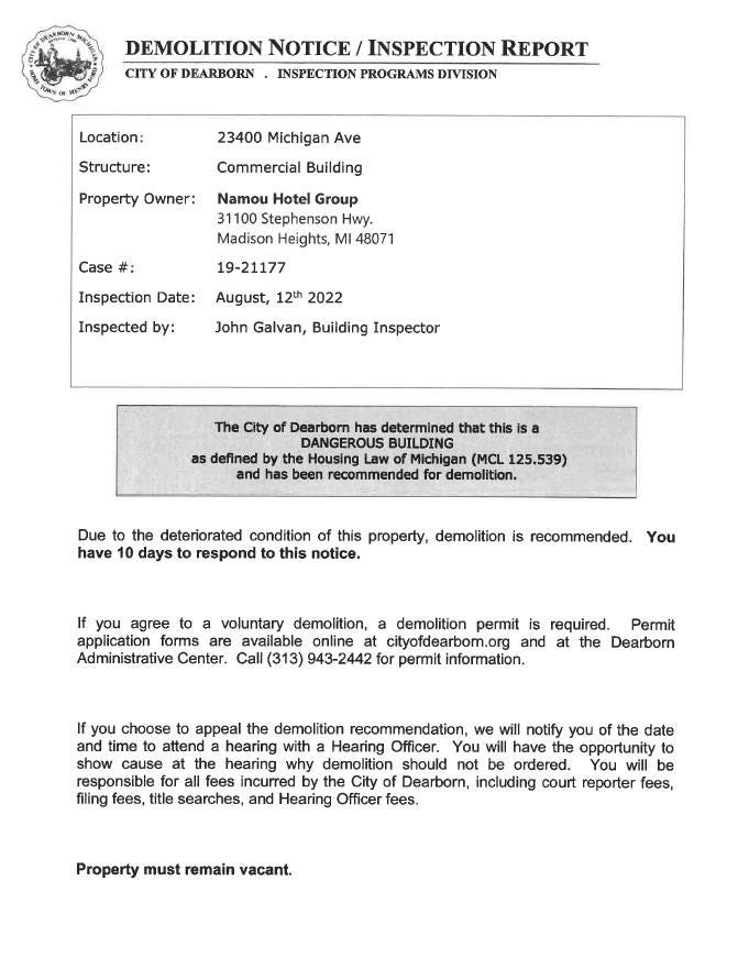 The official demolition notice served to Namou Hotel Group. The notice declares the property a "dangerous building" and provides instructions for agreeing to voluntary demolition or appealing the demolition.