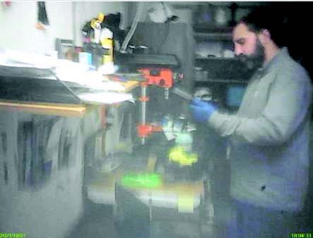 Man, right, cleaning a firearm in a workshop.