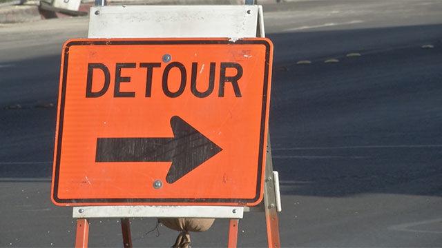 Detour sign warns drivers of an upcoming road closure ahead.