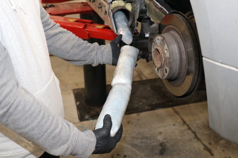 Hands holding rolls of powder fentanyl