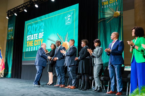 Detroit Mayor Mike Duggan shakes hands on stage at the State of the City address