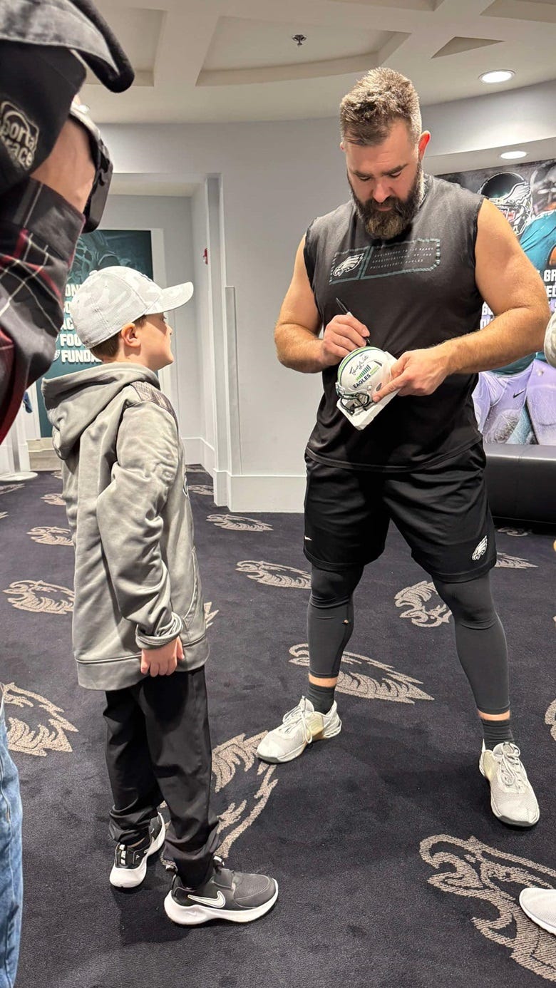 Jason Kelce signing JJ Thompson's hat