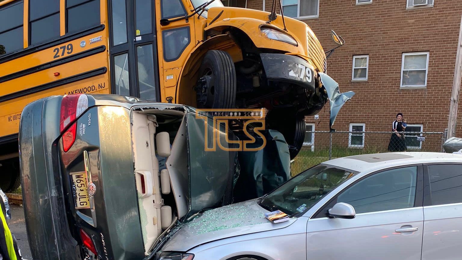 PHOTO: School bus carrying 15 students crashes and lands on top of cars; no injuries