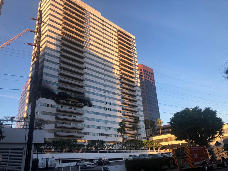 tall apartment building with fire damage about six floors up