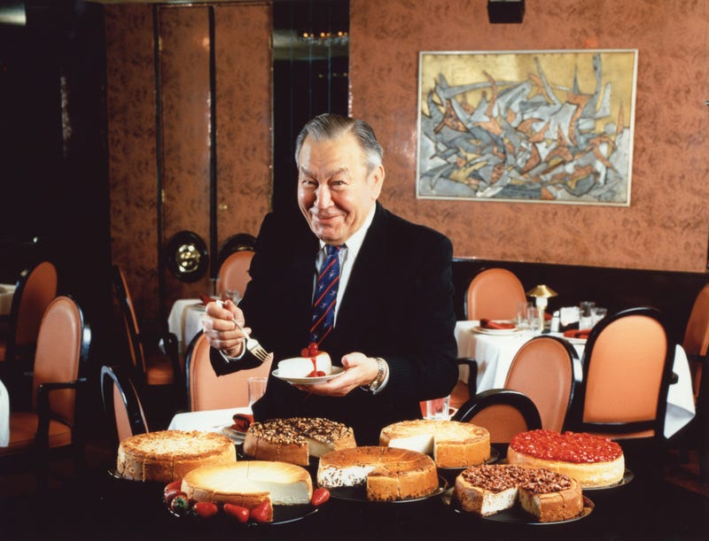 Eli Schulman poses for a photo with his famous cheesecake.