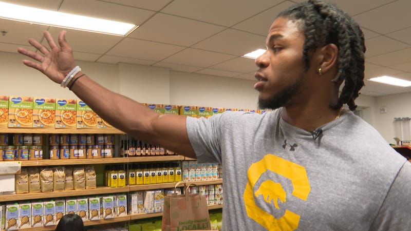 Cal football star Elijah Hicks helping at a food pantry.