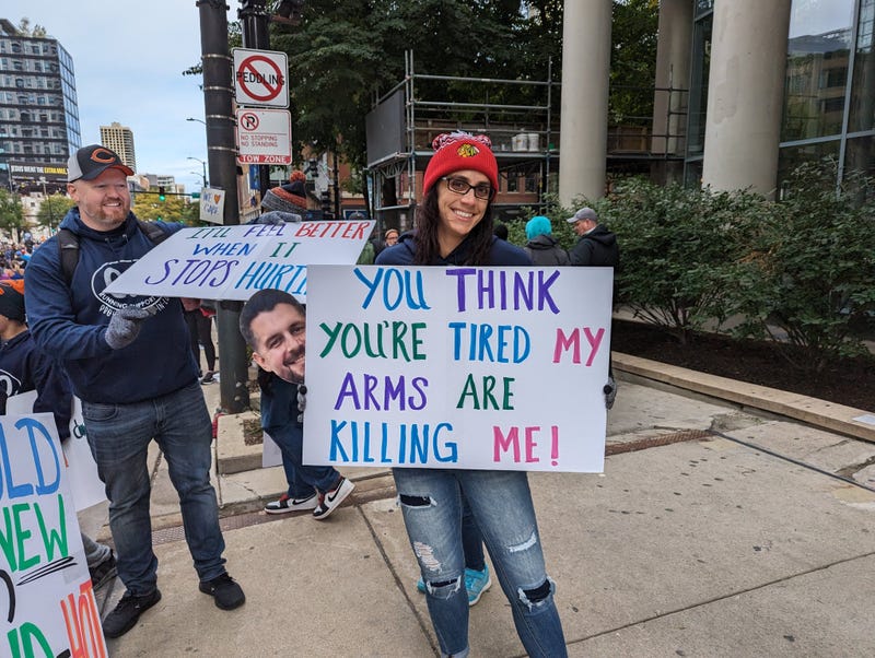 A Chicago Marathon supporter holds a sign that reads "You think you're tired, my arms are killing me."