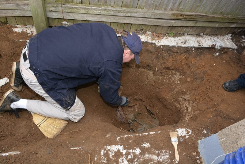 Investigators in the backyard of a home in Richmond Hill where Martin Motta buried the remains of George Clarence Seitz