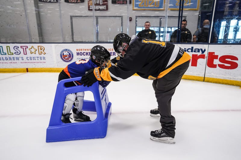 A Suffolk County Sheriff's Officer helps a youngster skate.
