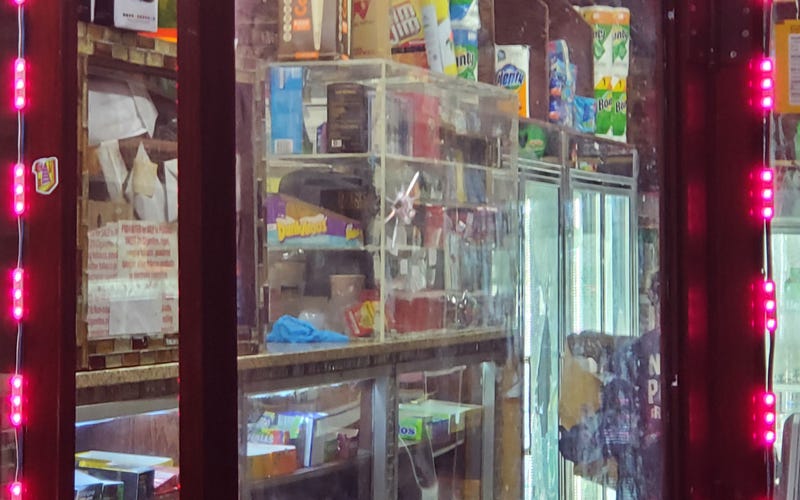 A bullet hole is seen in the glass door of the deli on Tuesday morning