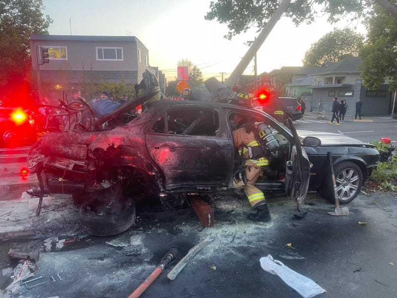 A man has survived a fiery car crash after Oakland residents used hoses and bottles of water to keep him alive until emergency crews arrived. 