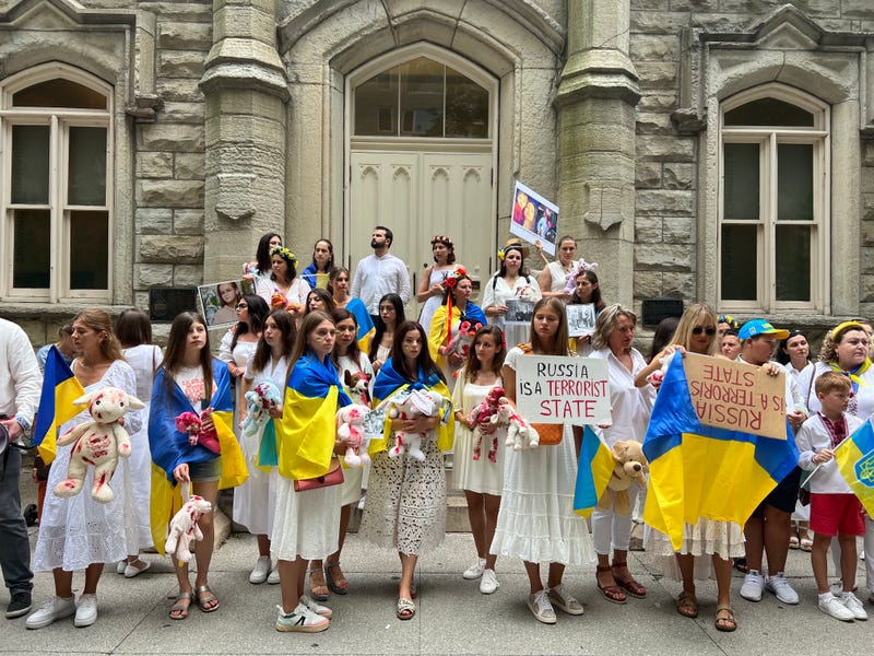 Protesters carry Ukrainian flags outside of Water Tower Place
