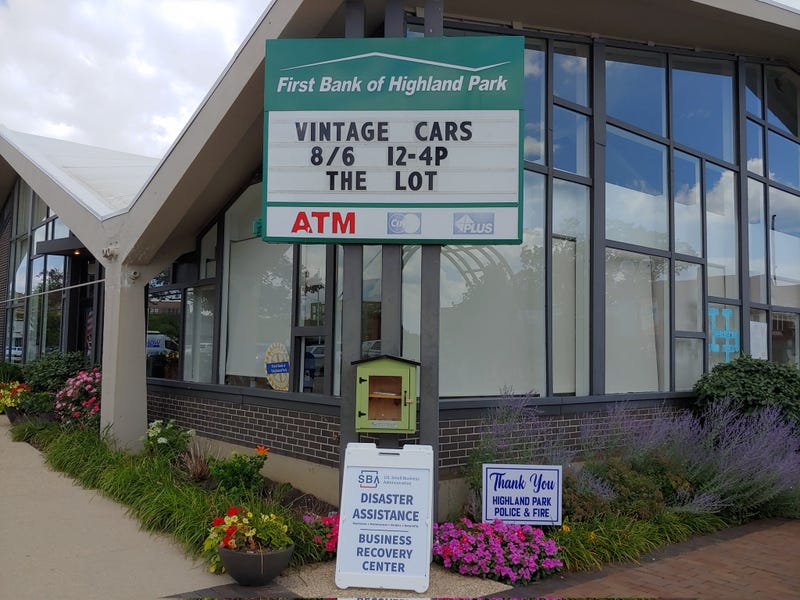 A fold-up sign advertises "disaster assistance" and a Business Recovery Center outside of the First Bank of Highland Park.