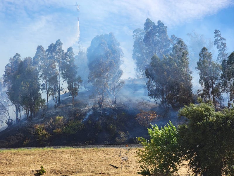 A three-alarm fire is burning in the East Bay, threatening homes and putting up smoke.