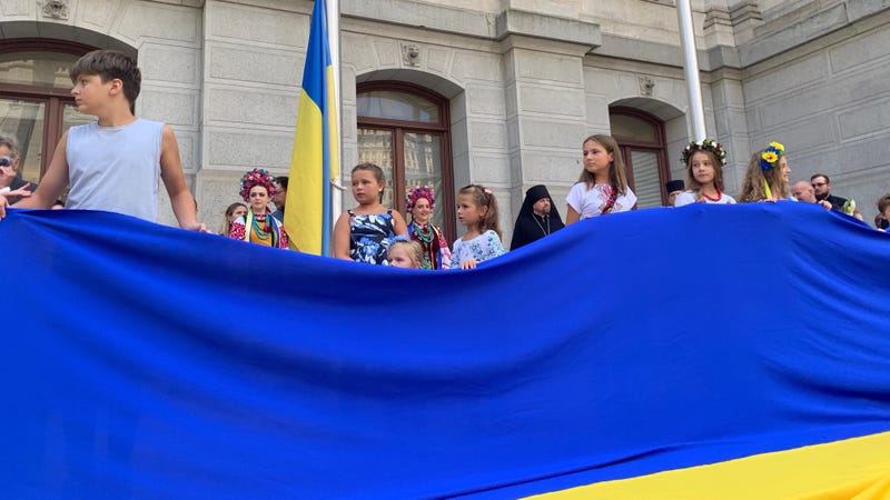 A large Ukrainian flag presented by children at a flag-raising ceremony at Philadelphia City Hall to mark the six-month anniversary of Russia's invasion of Ukraine.