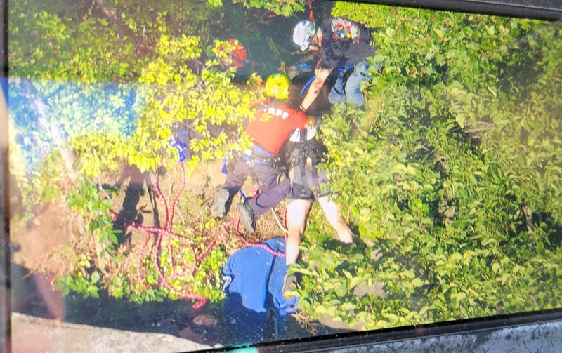 The man landed in a crevice between two rocks instead of falling 250 feet, officials said