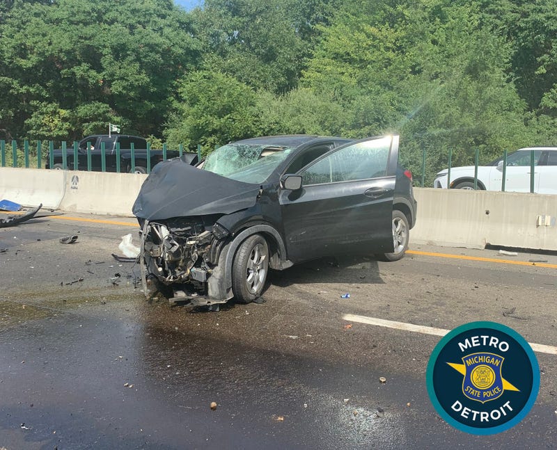 An overturned gravel hauler and hundreds of gallons of leaked fuel are hindering clean up efforts from a crash that injured two people on I-96 in Oakland County, officials say.