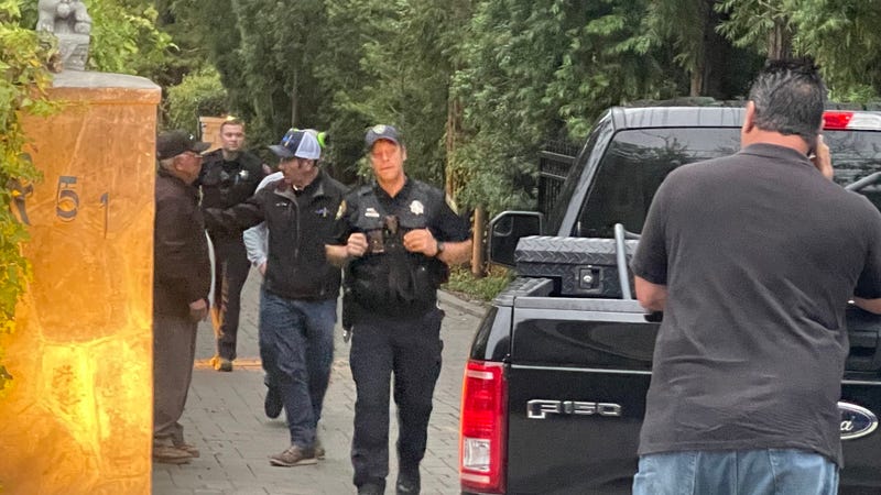 Police on Friday investigate the scene where a buried vehicle was found at an Atherton home.
