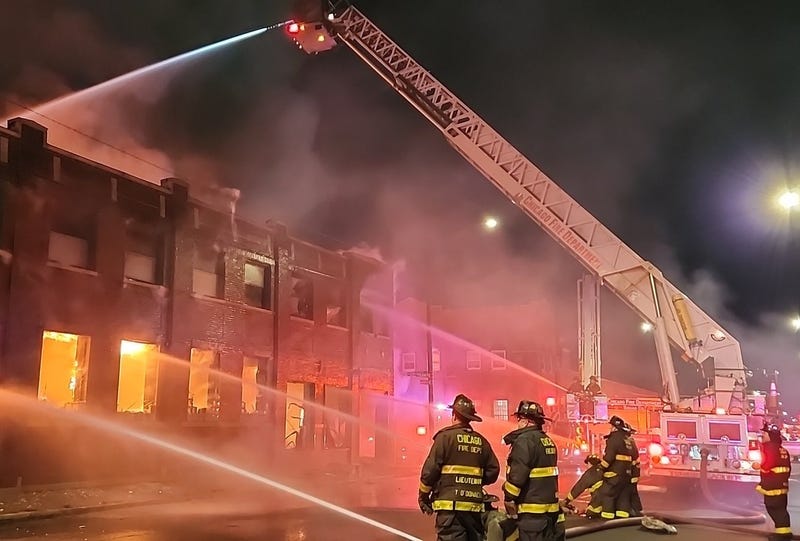 Firefighters spraying water on burning warehouse