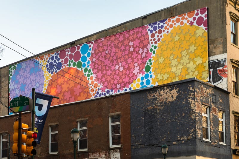 The "Floating Dogwood" mural by Michelle Tremblay and Polly Apfelbaum sits above Milkboy Philly, at 11th and Chestnut Streets.