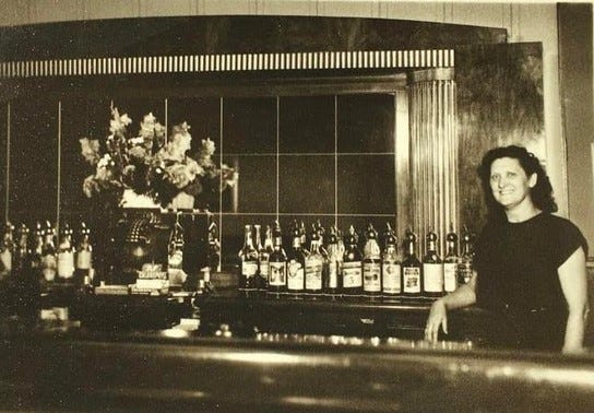 Flora Getzelman poses for a photo behind the bar inside Mott's Lounge. Flora and her husband Albert opened the bar inside of a garage in 1924.