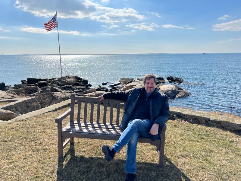 Dean Hacohen sits at the memorial bench on Rocky Point in Norwalk