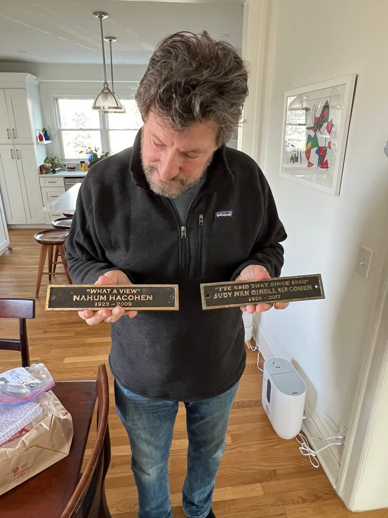 Dean Hacohen holds the plaques of his parents, Nahum and Judy Hacohen