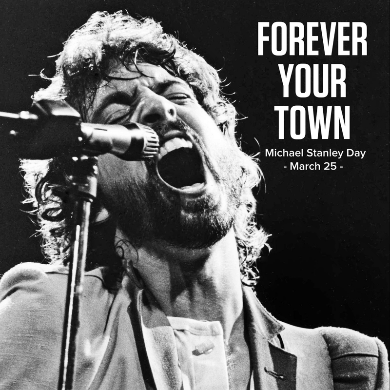 Michael Stanley singing into microphone with text of Michael Stanley Day as March 25th