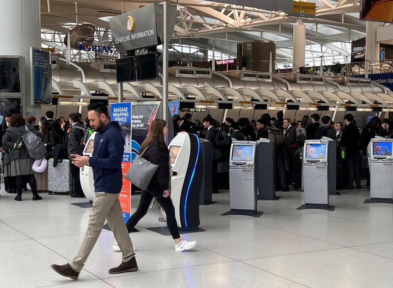 Passengers wait to be checked-in manually Thursday after a blackout at JFK Airport's Terminal 1