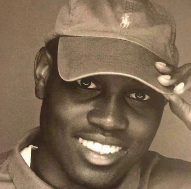 A photo of Ahmaud Arbery indicates that he is a dark-skinned black man