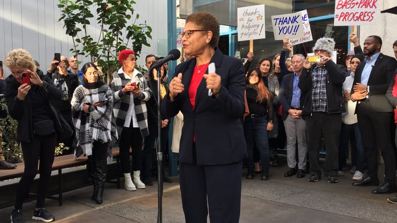 karen bass speaks at microphone in front of crowd