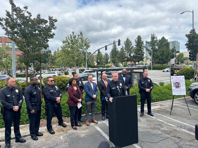 police official speaks at podium in parking lot