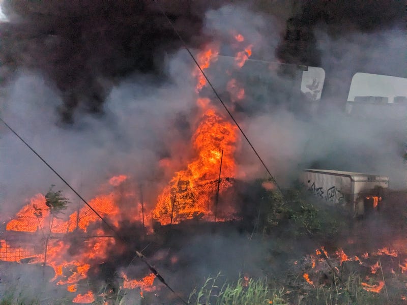 This image taken by a train passenger on SEPTA's Trenton Line shows the intensity of a three-alarm fire at a junk yard and recycling facility in the area of Harbison Street and Torresdale Avenue in Northeast Philadelphia.