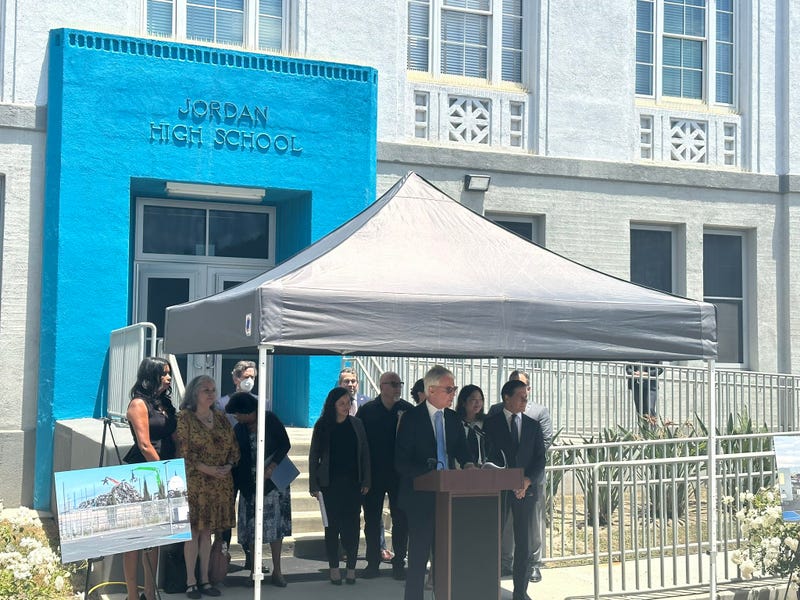 george gascon speaks at podium in front of jordan high school
