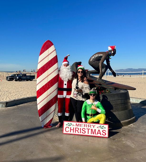 Santa and his helper surfing at Hermosa Beach. 