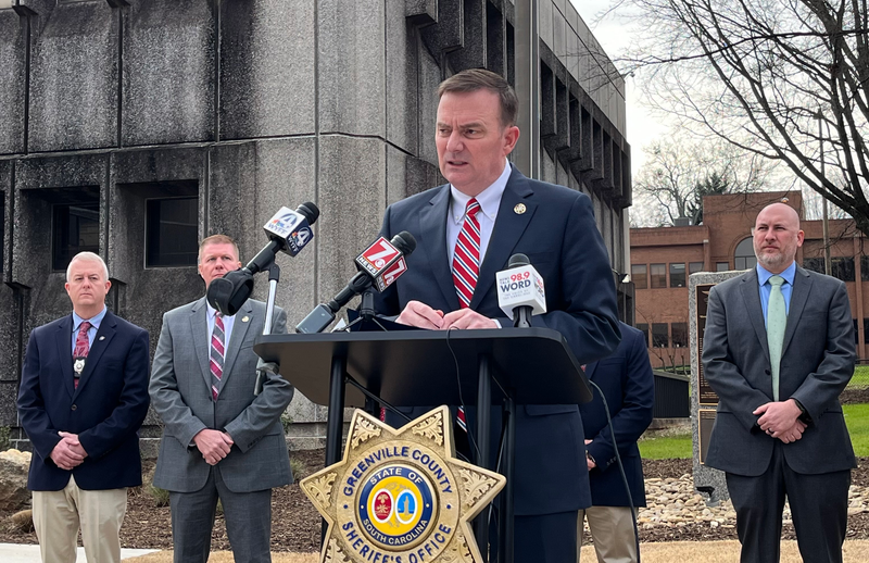Greenville County Sheriff Hobart Lewis speaking at a press conference flanked by members of the GCSO Cold Case investigation unit