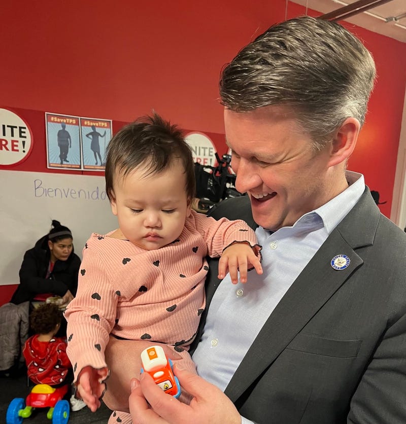 Ald. Bill Conway holds a baby at a free legal aid clinic for migrants that took place in Chicago's Loop on Saturday. 