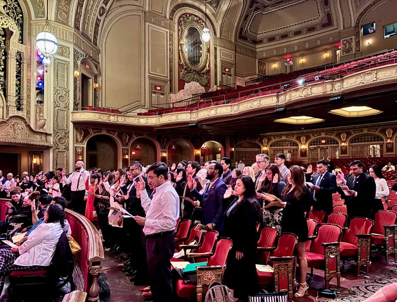 Over 100 people took the Oath of Allegiance to the United States as they became naturalized U.S. citizens on Tuesday inside Joliet's Rialto Theater.