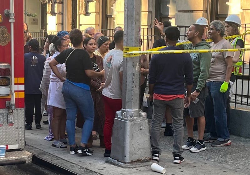 People gather outside the building on West 178th Street