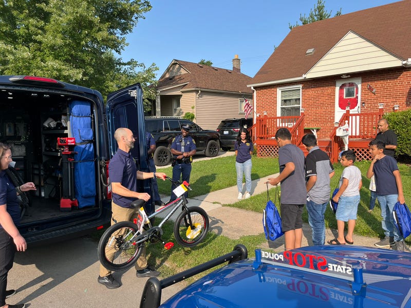 Police officer giving bikes to kids