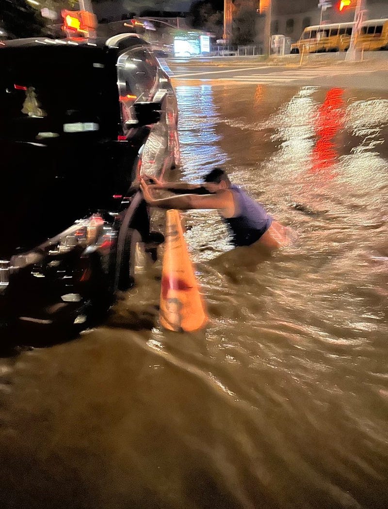 The SUV was partially submerged by the floodwaters, hiding the sinkhole below the surface