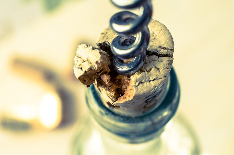 cork breaking on wine bottle