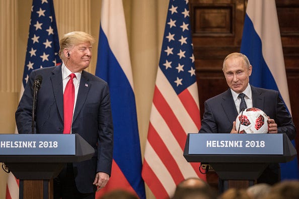 Russian President Vladimir Putin hands U.S. President Donald Trump (L) a World Cup football during a joint press conference after their summit on July 16, 2018 in Helsinki, Finland. 