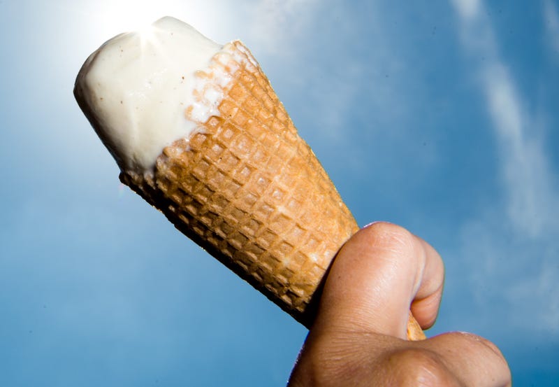 A cone with a scoop of vanilla ice cream is held up by a woman in Sehnde, Germany, July 2017.
