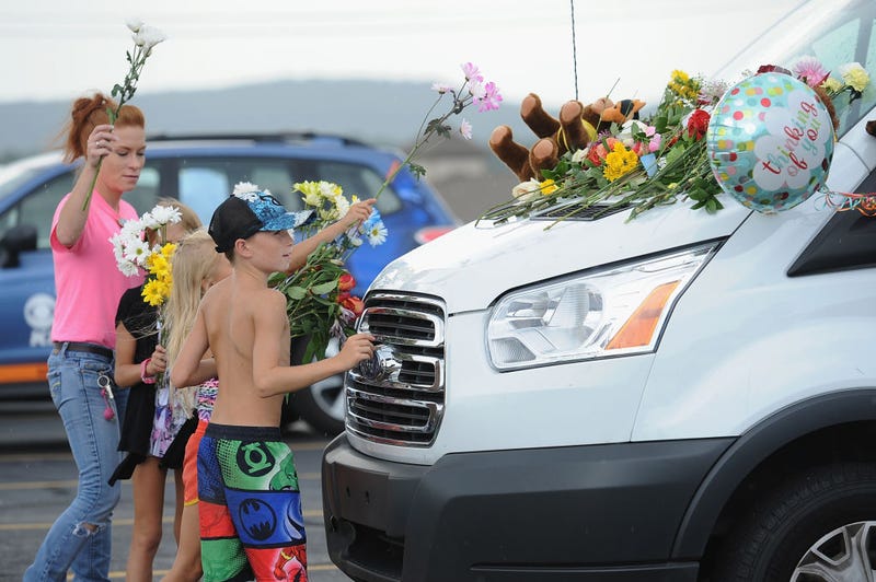 A family places flowers on vehicles of the victims of the Ride The Ducks accident on July 20, 2018 in Branson, Missouri.