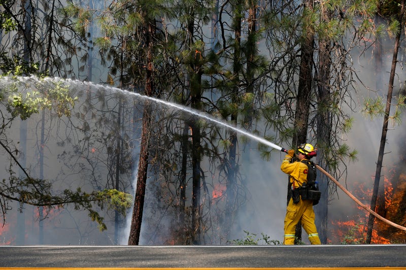 Firefighter Derek Longoria, of CalFire's Shasta-Trinity Unit, extinguishes flames near State Highway 299 while battling the Carr Fire on July 30, 2018 near Redding, California.