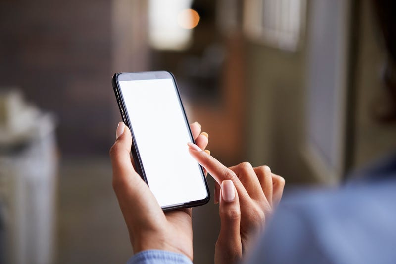 Female holding smartphone with blank screen
