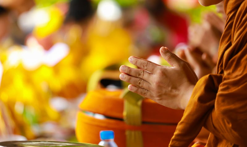 Hand of monk in Buddhist prayer process.